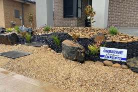 new home landscaping with creative gardens sign